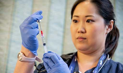 A nursing student fills a needle